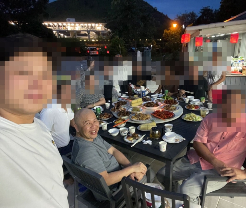 朋友与洞鈜法师合照,桌上放有多碟肉类。 朋友与洞鈜法师合照,桌上放有多碟肉类。