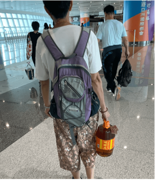 港大妈单手提着一桶4公升,约重3.8公斤的食用油 港大妈单手提着一桶4公升,约重3.8公斤的食用油