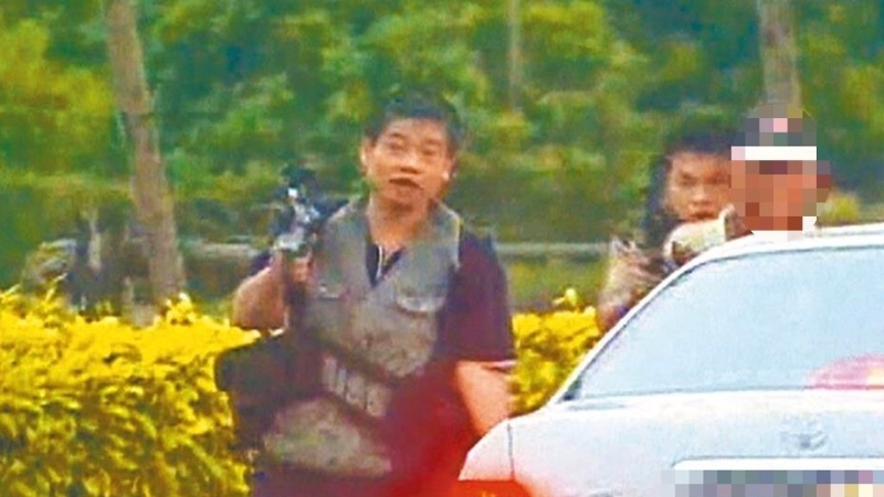 “台湾张子强”张锡铭(左一)2004年与同伙被围捕时挟持1名老农(右一)和警察街头枪战。 “台湾张子强”张锡铭(左一)2004年与同伙被围捕时挟持1名老农(右一)和警察街头枪战。