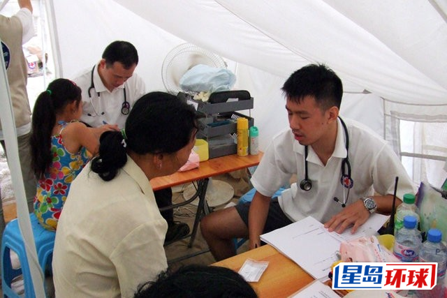 洪几正(右一)为灾民诊症。 洪几正(右一)为灾民诊症。
