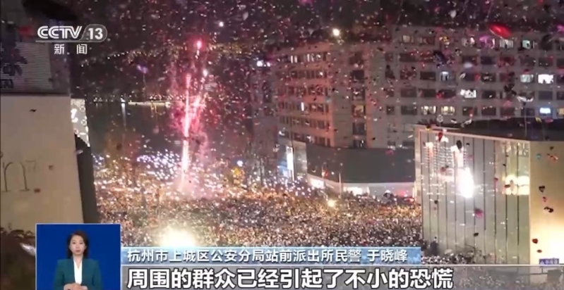 男子在人群中放烟花，当时天空中有很多气球。