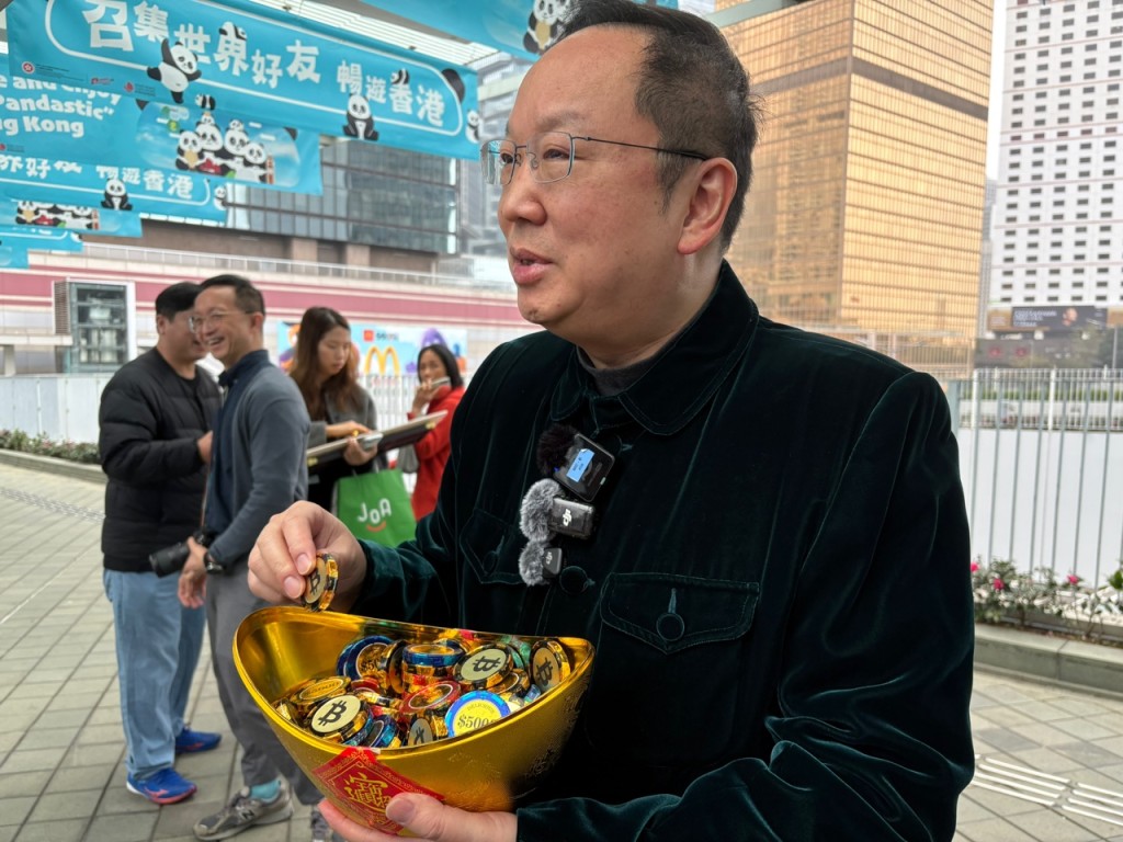 陈仲尼向市民派朱古力金币。 陈仲尼向市民派朱古力金币。