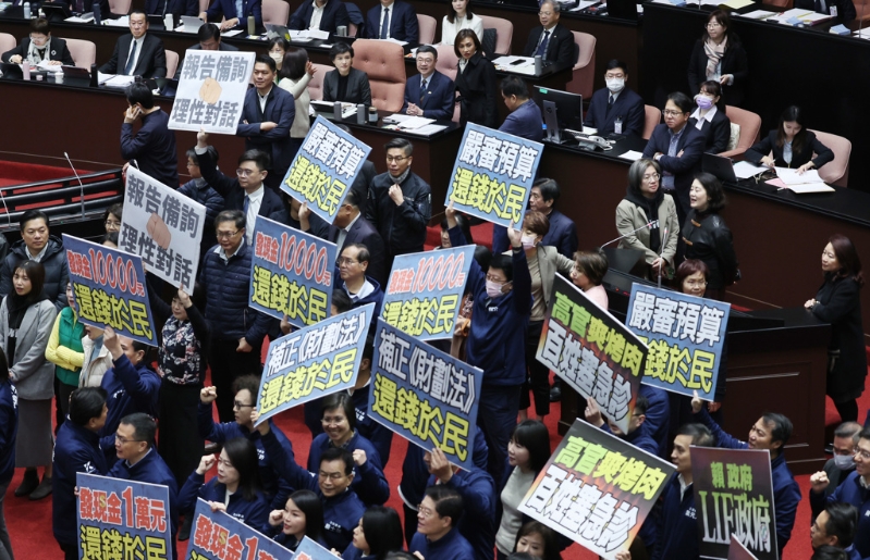 国民党“立委”手持“严审预算，还钱于民”等标语抗议。