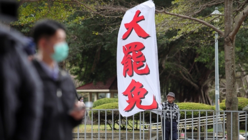 图为民众在民进党中央党部楼下高举旗帜，要求党主席赖清德对大罢免表态。