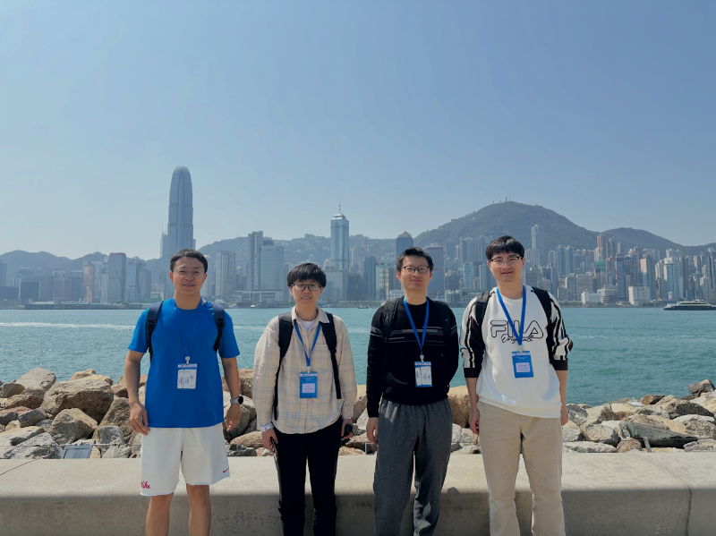 参会者在西九文化区合照，背后是维港和港岛