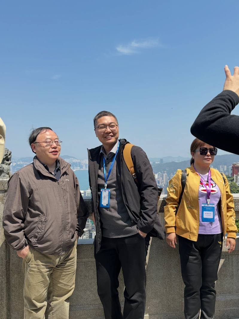 参会者在太平山山顶广场合照，可以看到背后的维港和对岸的九龙