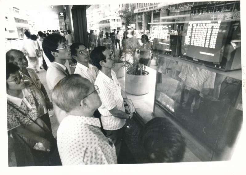 1987年股市疯狂暴泻下，商业区的股价传真吸引大批股民围观市况。资料图片
