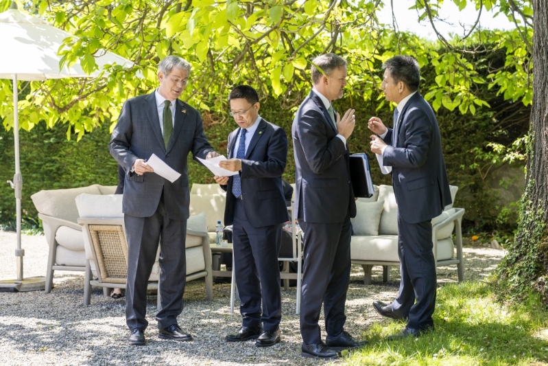 双方代表团在户外交谈。