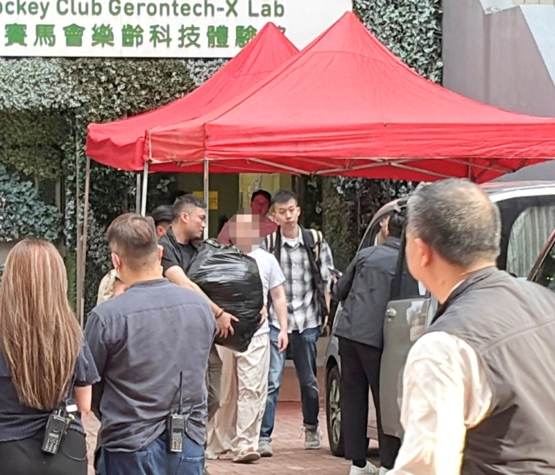警方6月5日押解其中一名被捕人到宿舍搜证。资料图片