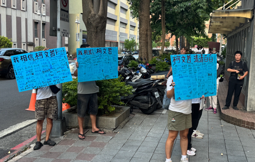 声援柯文哲的民众5日在台北地院外举着海报，高喊“柯文哲，清清白白”。