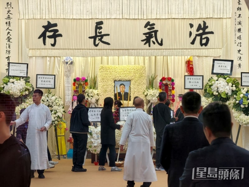 灵堂内，中央摆放了何伟豪的遗照及“浩气长存”四个大字。