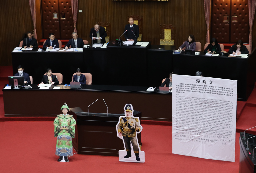 蓝白2党将赖清德着袁世凯戎装称帝及身穿龙袍的合成照和弹劾文放在议场中央。