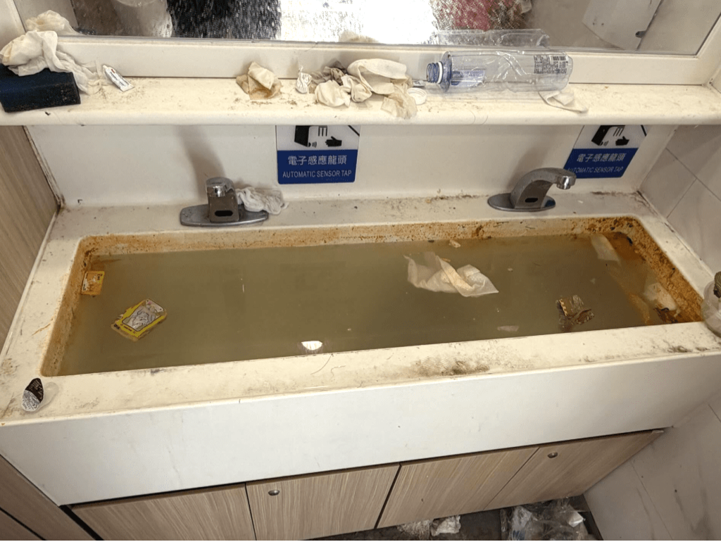 厕所洗手盘满布污泥、积水和废弃物。 厕所洗手盘满布污泥、积水和废弃物。