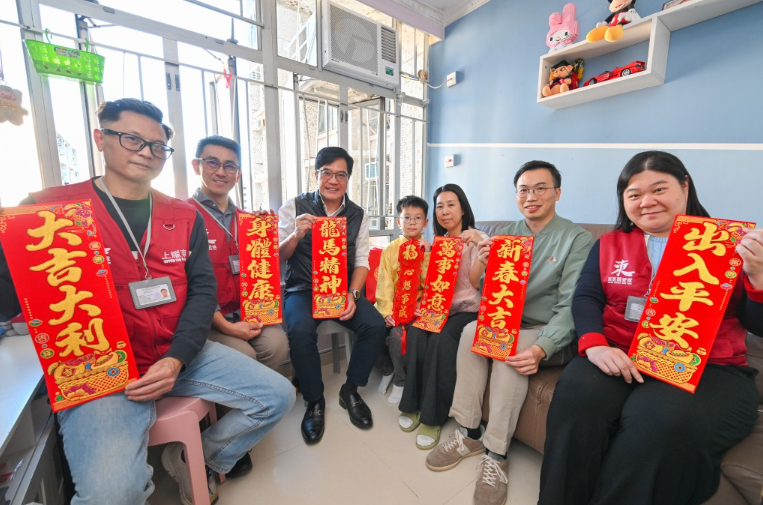 财政司副司长黄伟纶（左三）在东区民政事务专员黎旨轩（右二）陪同下，联同东区区议员和关爱队代表，探访居于耀东邨的家庭，聆听他们的生活点滴，并送上新春祝愿。