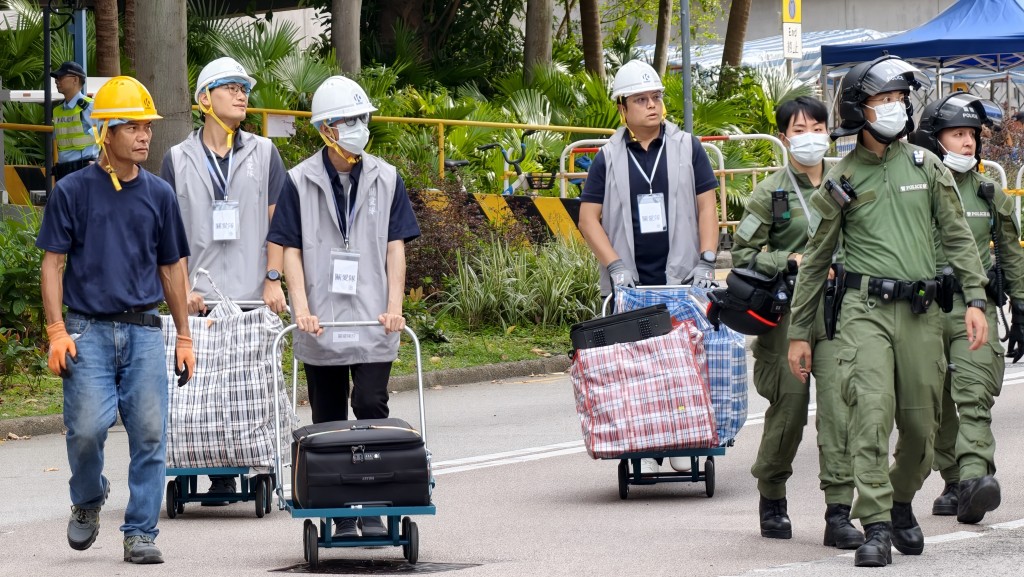 有义工、民安队及警方人员协助居民由单位搬运物品。